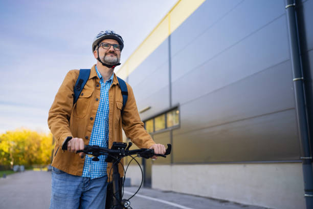 istock Mid-adult Caucasian man pushing the bicycle, while commuting to the work 2180931816