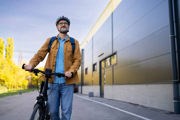 istock Mid-adult Caucasian man pushing the bicycle, while commuting to the work 2180931834