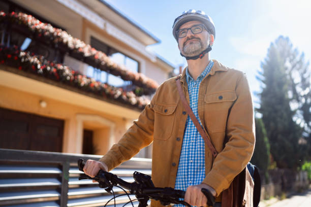 istock Mid-adult Caucasian man pushing the bicycle, while commuting to the work 2180931908