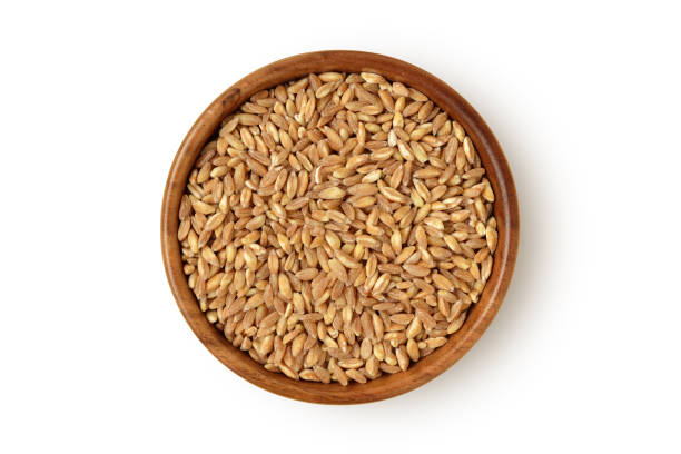 istock Pearled whole emmer wheat (Farro) in wooden bowl on white background 2180935106