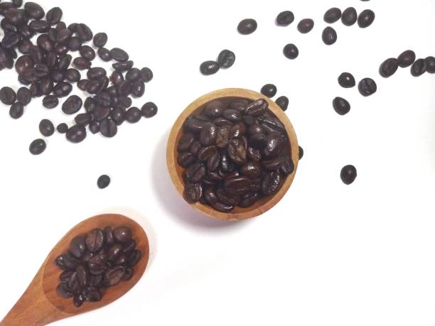 Roasted coffee bean on small wooden bowl and spoon isolated on white background with copy space