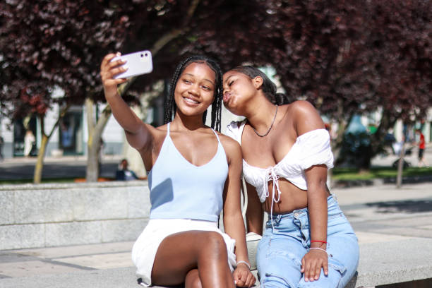 istock Two black women sitting and smiling and posing for a selfie 2180938843