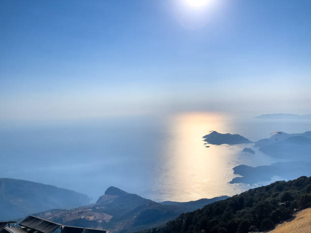 Paraglider Flying Above Ocean With Scenic Mountain and Island View