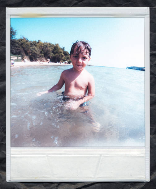 istock Young Boy Playing in the Shallow Water at the Beach 2180944704