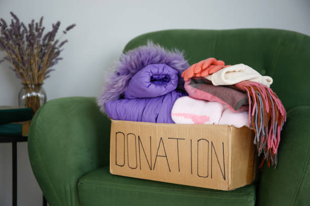 Donation box with clothes on the sofa in the living room.
