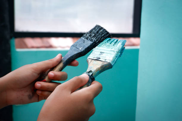 istock Hand of person holding a brush for wall paint 2180944933