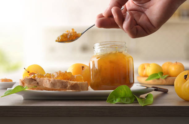 istock Person preparing toast with plum jam on a kitchen bench 2180945278
