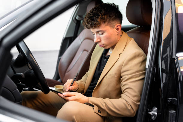 istock Young businessman killing time inside the car 2180945447