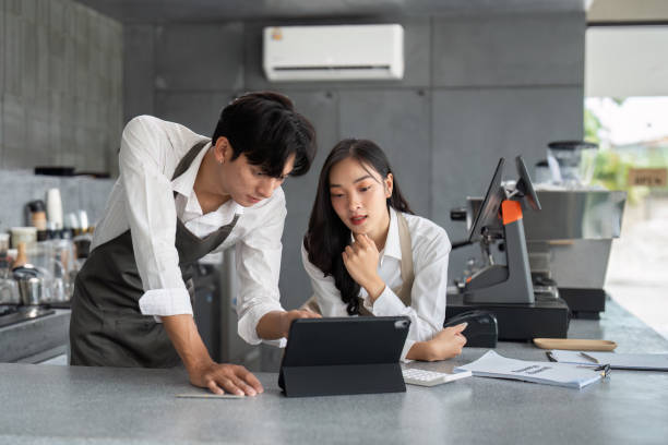 istock Young Baristas Collaborating in Modern Coffee Shop with Digital Tablet and Espresso Machine 2180947802