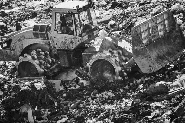 Aerial shot of a vast landfill with a yellow bulldozer moving refuse, highlighting pollution and waste management challenges in a busy dump site.