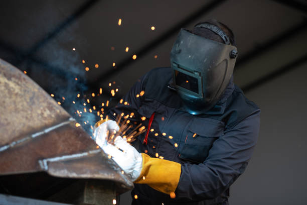 istock Industrial worker welding metal with sparks flying in workshop 2180953562