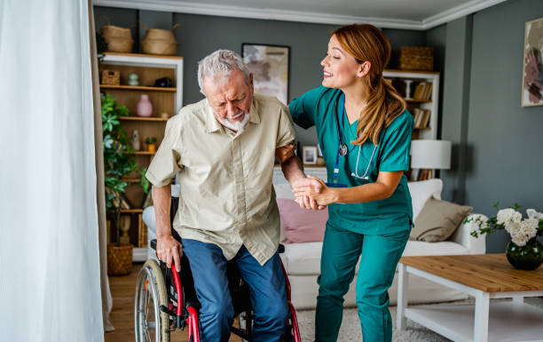 istock Nurse helping a senior man get up from a wheelchair 2180953572