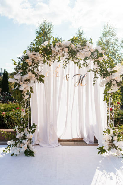 istock Elegant Floral Wedding Arch with Drapery and Initials 2180954419