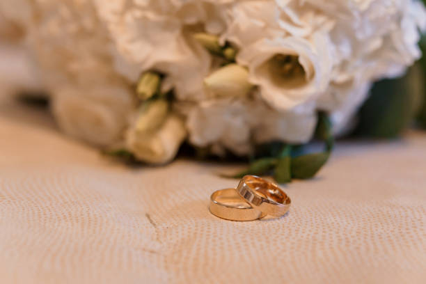 istock Elegant Wedding Rings Beside a Beautiful Floral Arrangement 2180954432