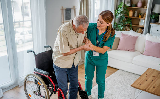 istock Nurse helping a senior man get up from a wheelchair 2180954488