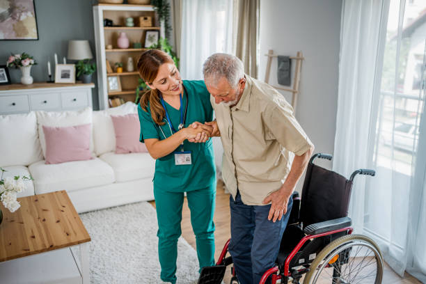 istock Nurse helping a senior man get up from a wheelchair 2180954614