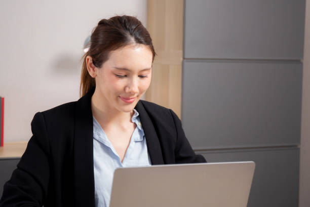 istock Young caucasian woman sitting and using laptop computer planning for success in modern office, businesswoman typing and watching notebook with confident, employee working on desk, business concept. 2180955218