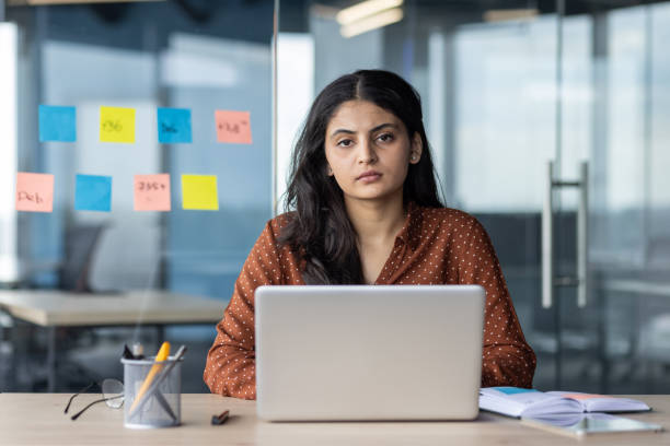 istock Confident young woman working at desk with laptop in modern office setting, surrounded by colorful sticky notes emphasizing planning and organization 2180956023