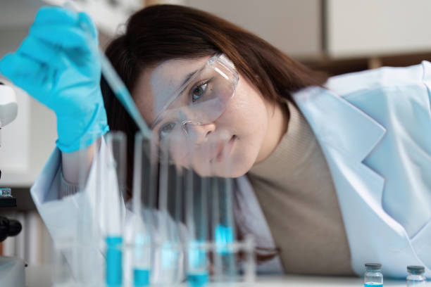istock Scientist Conducting Experiment in Modern Laboratory with Test Tubes and Protective Gear 2180956163