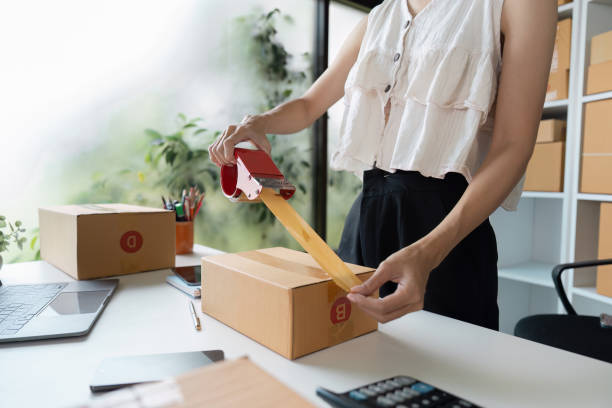 istock Small Business Owner Packing Order for Online Sales in a Modern Home Office 2180956621