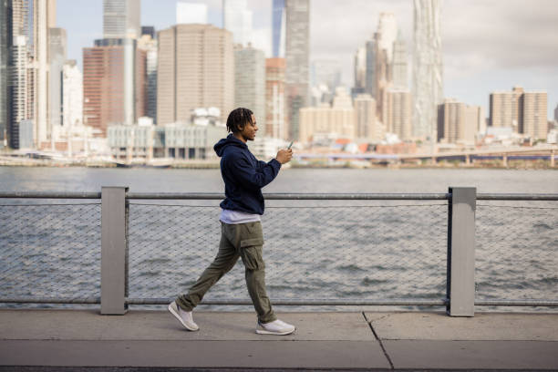 istock Happy African American man using mobile phone on the move by the river. 2180958375