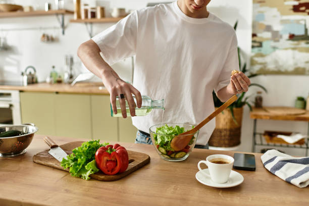 istock A young man makes a fresh salad in a modern kitchen on a sunny day 2180960365