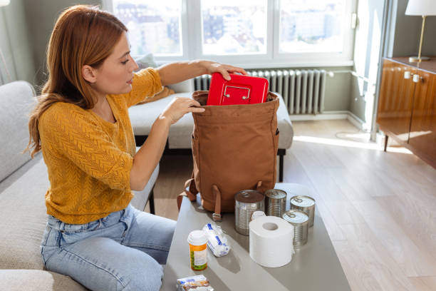istock A woman organizing a survival backpack with essential supplies 2180960482