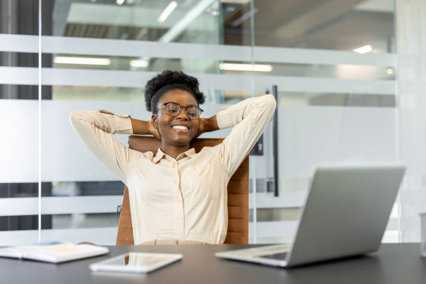 istock Happy businesswoman relaxing at office desk while taking a break from work, enjoying moment of success and relaxation 2180963305