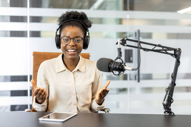 istock Confident woman recording podcast with microphone and headphones in modern office setting 2180964021