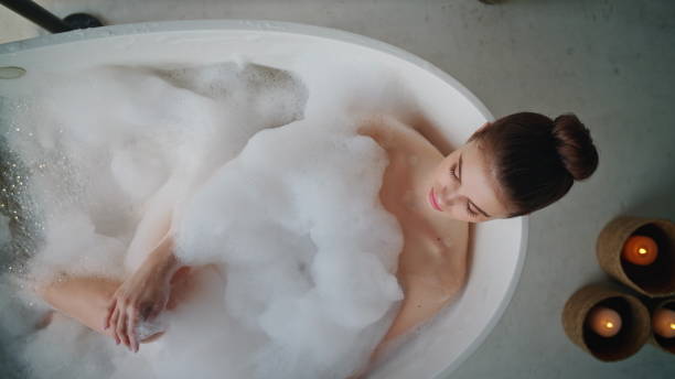 istock Girl lying foam bath at bathroom morning routine top view. Woman relaxing 2180964277