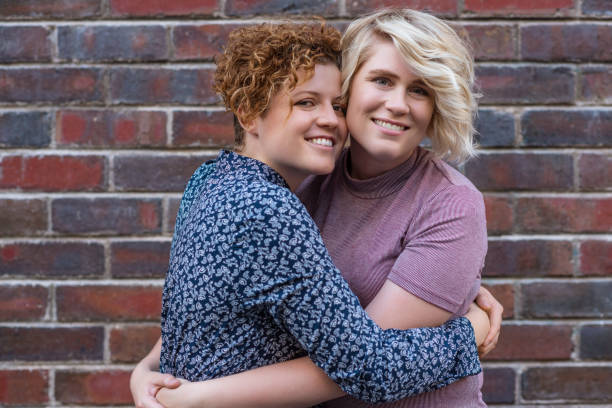 istock Young woman giving her smiling girlfriend an affectionate kiss 2180964878