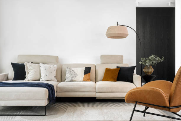Modern living room with a beige sofa, decorative cushions, and stylish lighting
