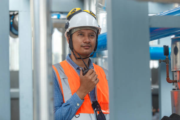 istock Male operator worker walkie talkie using tablet checking quality cooling air piping HVAC system at industrial building. Man engineer working Heating Ventilation and Air conditioning system. 2180975964