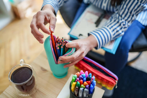 Woman using color pencils for sketching at home.