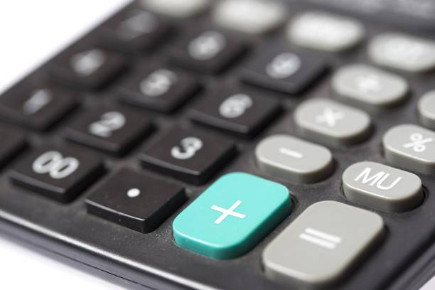 Close up of a black calculator with green plus button