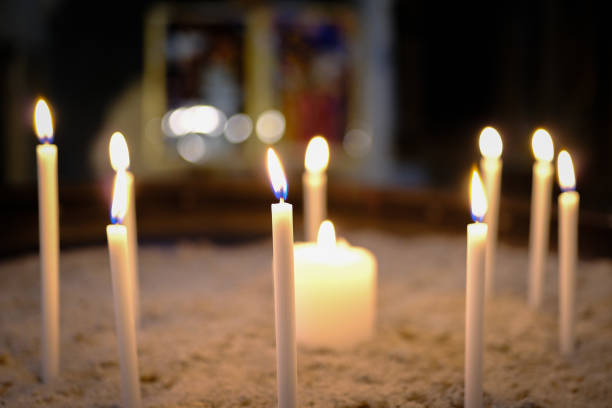 Votive prayer candles inside a Catholic church in the sand.