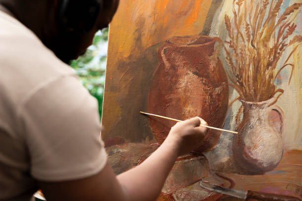 Confident artist stands before a canvas creating a beautiful painting