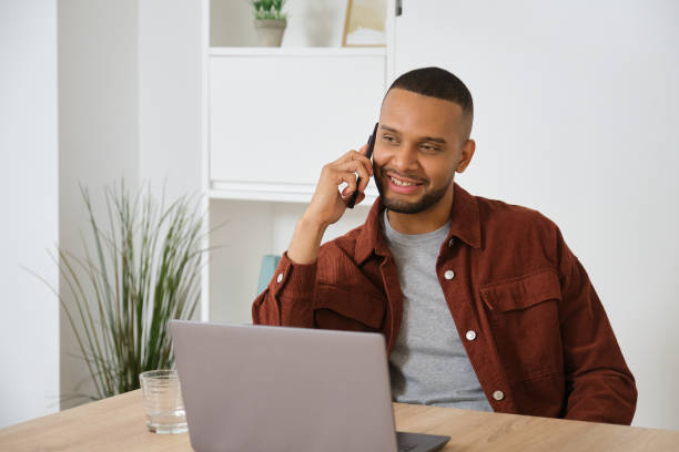 istock Young entrepreneur working from home talking on phone and smiling 2180993879
