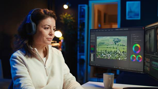 Video editor polishing raw footage, applying modern editing techniques in order to enhance sound and visual quality. Videographer adjusting clips while listening music in headphones, camera B