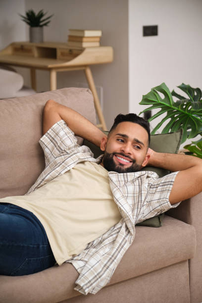 istock Young man relaxing on comfortable sofa at home 2180995435