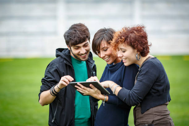 istock Students using tablet and smiling in front of pisa cathedral, italy 2180997162