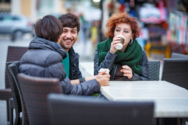 istock Friends drinking coffee at outdoor cafe in urban setting 2180997434
