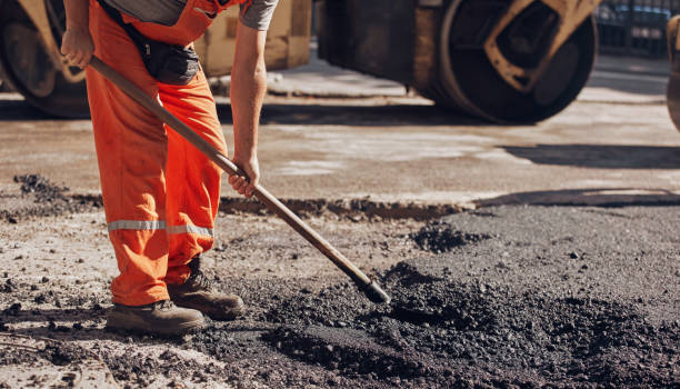 istock Construction workers working on a new asphalt layer on a public street. 2180998457