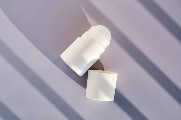 istock Roll-on deodorant on a purple background with shadow stripes. 2181003327