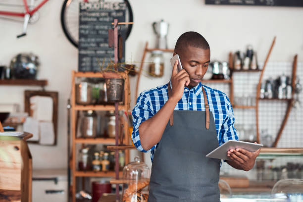 istock Young cafe owner hard at work in his trendy cafe 2181003451