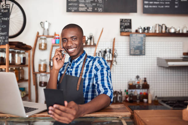istock Smiling African entrepreneur talking on the phone in his cafe 2181003614