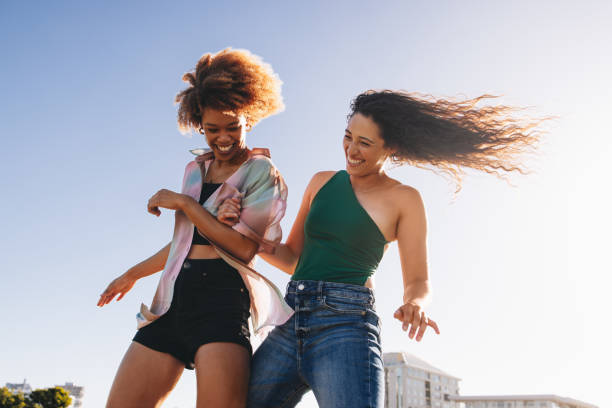 istock Energetic young friends dancing and laughing outdoors 2181005220
