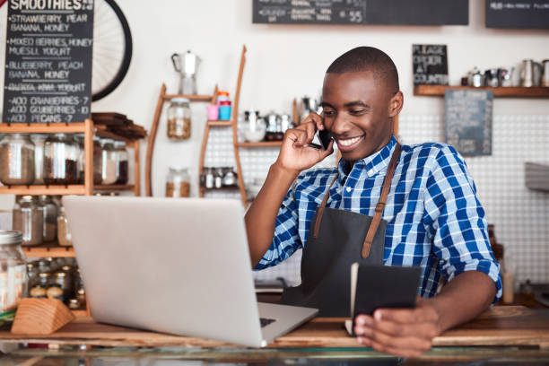 istock Smiling entrepreneur hard at work on his cafe business 2181005259