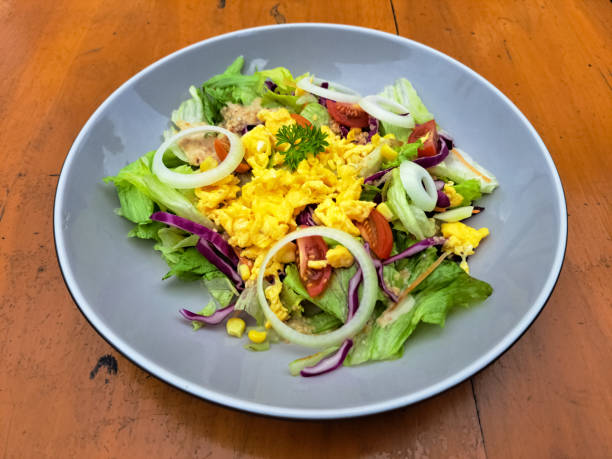 Delicious Asian Egg Salad With Sesame Dressing - Scrambled Eggs Served With Lettuce, Purple Cabbage With Sesame Sauce, Roasted, Corn, Cherry Tomatoes And Sliced ​​Onions. Salad Food Menu.
