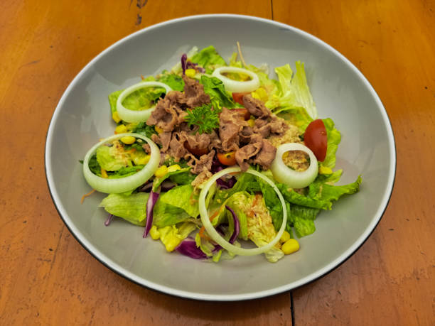 Tokyo Beef Salad With Sesame Dressing - Grilled Beef Slices Served with Lettuce, Purple Cabbage With Sesame Sauce, Roasted, Corn, Cherry Tomatoes And Sliced ​​Onions. Salad Food Menu.